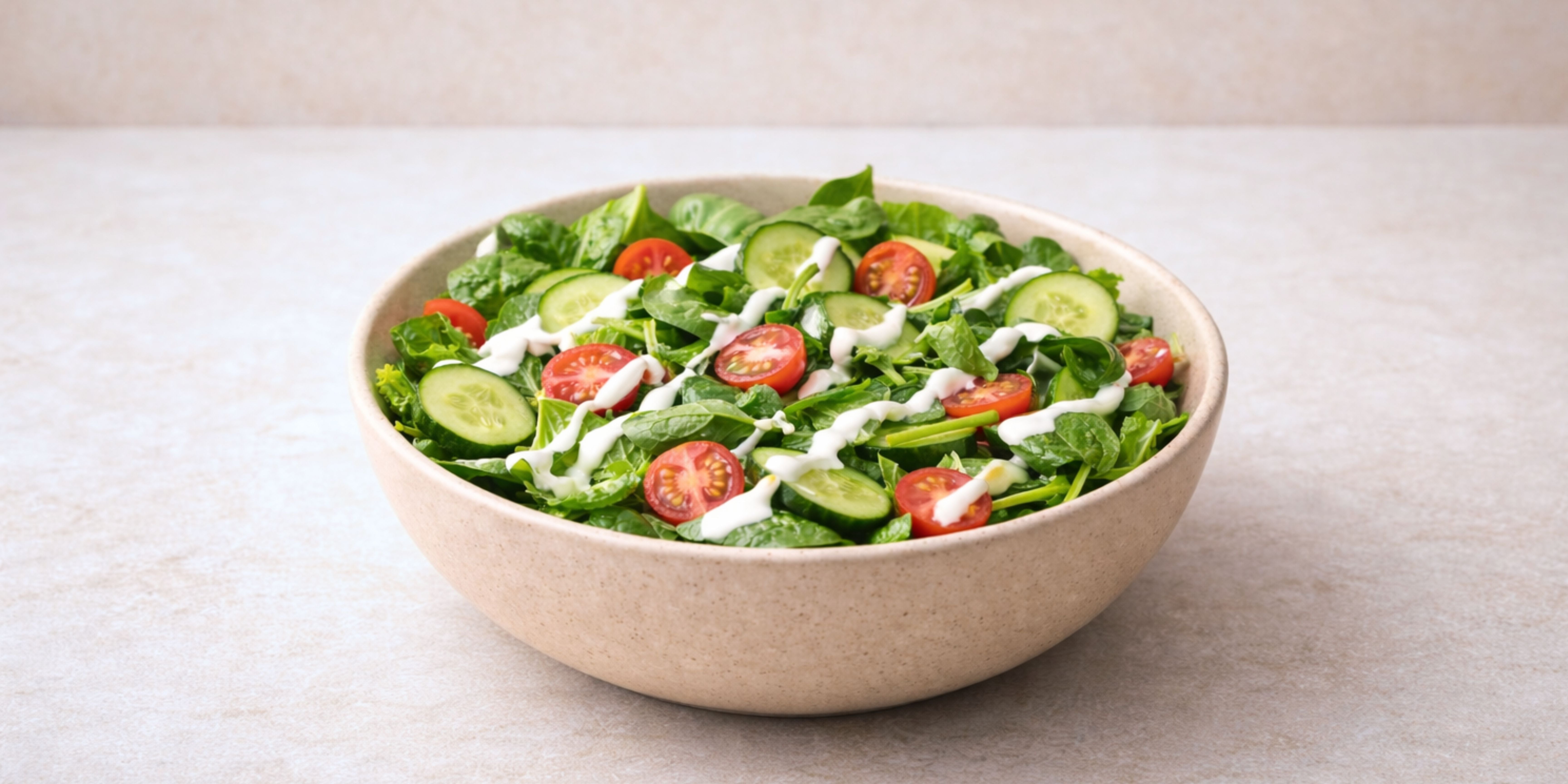 Ein bunter Salat mit Tomaten und Gurken und kollagen pulver sauce in einer beigen Schuessel