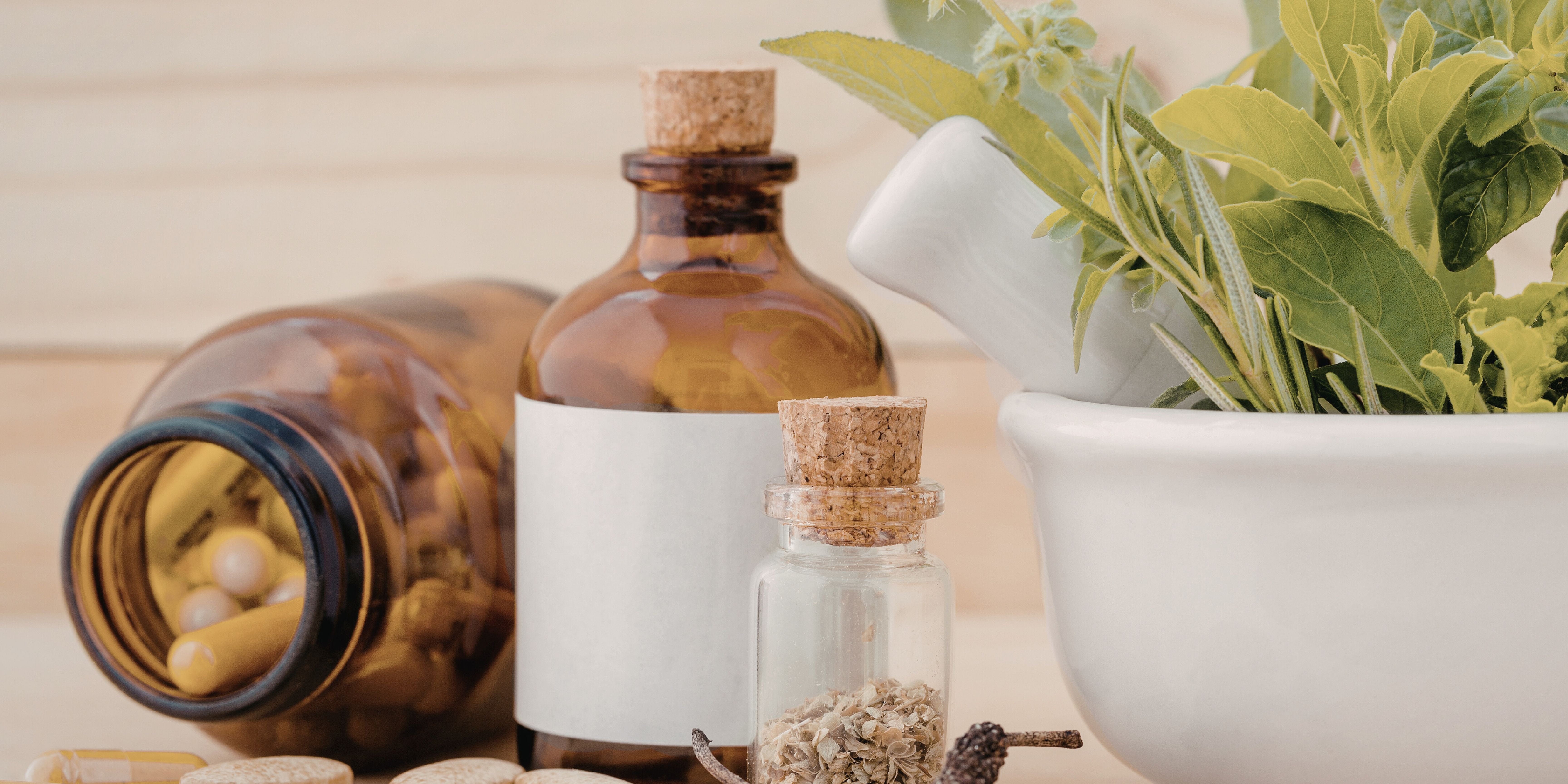 drei glass flaschen, kapseln und eine pflanze 