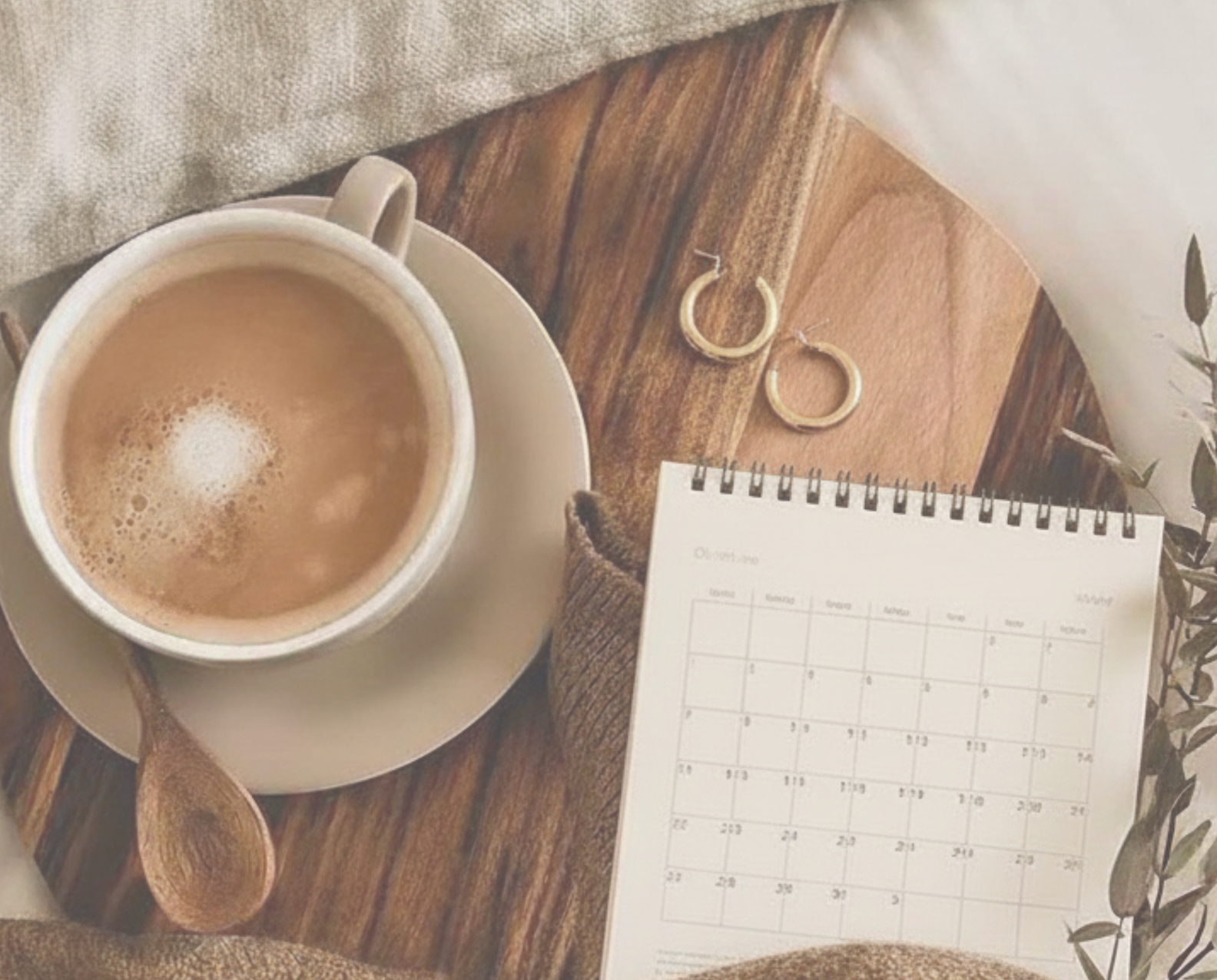 Tasse Kaffee, Notizbuch und Kalender auf einem Holztisch von oben fotografiert