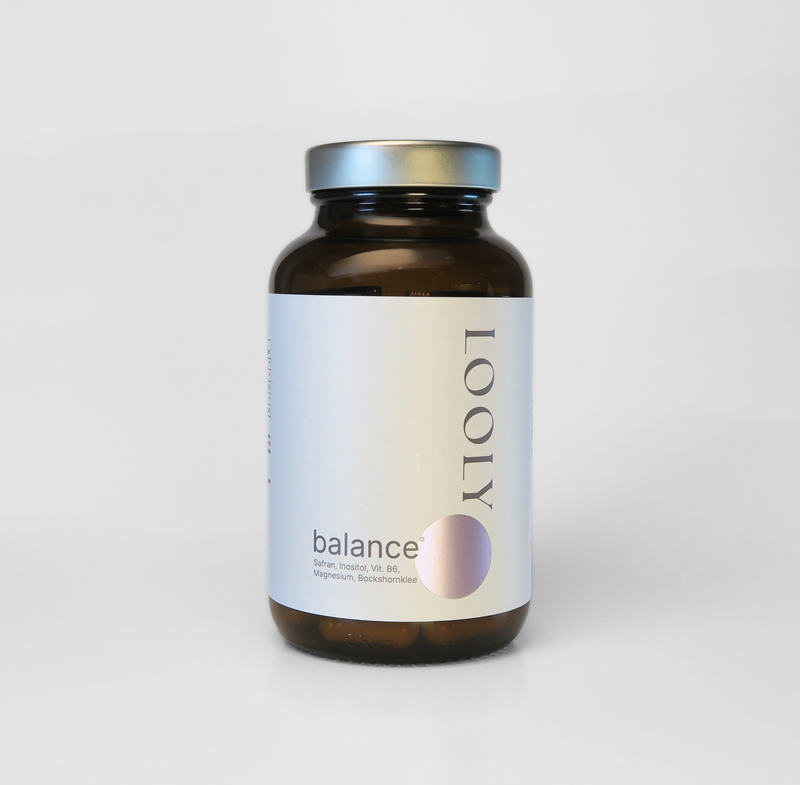 „LOOLY balance Nahrungsergänzungsmittel in brauner Glasflasche mit Kapseln und minimalistischem Etikett vor hellem Hintergrund.“